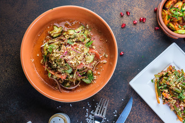 Healthy salad with spinach, arugula, red onion and pomegranate in plate on dark concrete background. Copy space