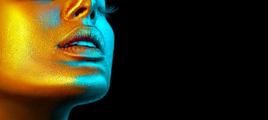Model Frau Gesicht in hellen Scheinen, bunten Neonlichtern, schönen sexy Mädchenlippen. Trendiges, leuchtendes Goldhaut-Make-up. Glitzerndes Make-up mit metallischem Glanz © Subbotina Anna