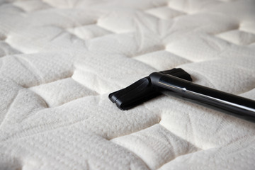 cleaning mattress by vacuum cleaner. dust mites on bed, texture. concept : allergy in bed room.
