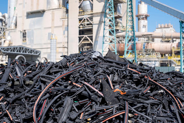 Pile of shredded waste rubber in front of rotary cement kiln used as alternative fuel