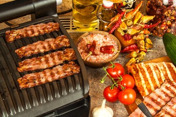 Grill steak on an electric stove. Pork neck fried on small electric grill. Home cooking. Healthy barbecue. Catering to friends. Electric grilling.