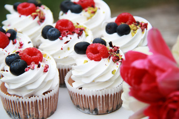 Homemade pavlovas cupcakes with berries and tulips