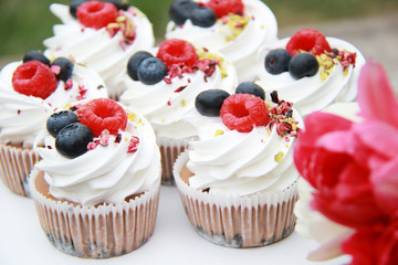 Homemade pavlovas cupcakes with berries and tulips