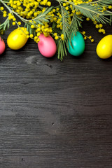 Easter background with mimosa, eggs and wooden surface