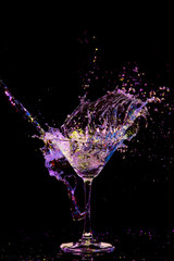 Splash Photography. Burst of Colorful Liquid in Wine Glass. Isolated Over Black Background