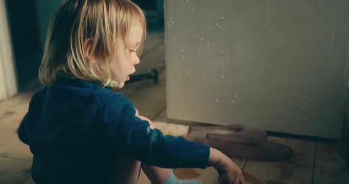 Little toddler pretending to paint a door with water