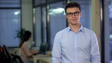 Handsome male employee in formalwear and eyeglasses looking camera, business