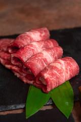Raw mabled sliced beef on black stone board