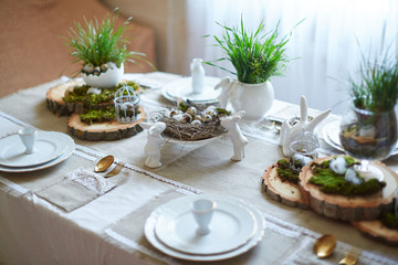 Easter table set. Decorated with eggs, nests and flowers.
