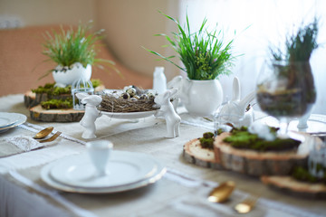 Easter table set. Decorated with eggs, nests and flowers.