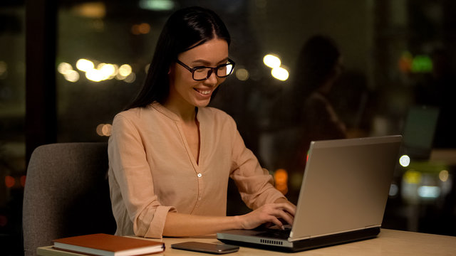 Smiling support service worker chatting client laptop, happy female freelancer