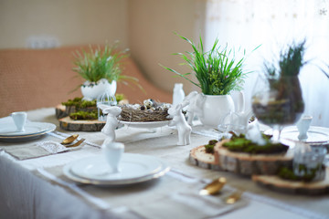 Easter table set. Decorated with eggs, nests and flowers.