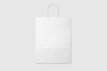 Mockup of a blank white paper shopping bag with handles on light grey background. High resolution.