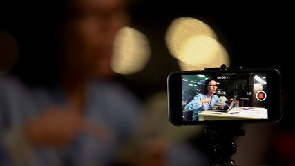 Female blogger pointing at money hand shooting business video, online training