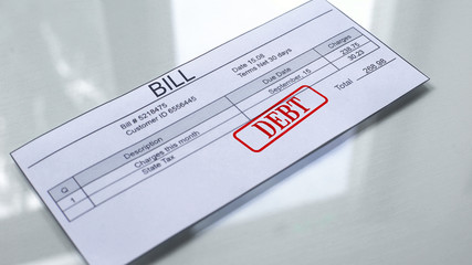 Fototapeta premium Debt seal stamped on bill, payment for services, month expenses, close up