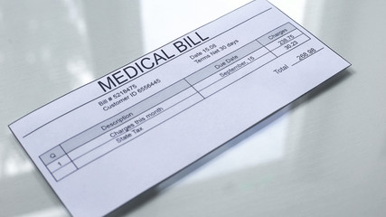Medical bill lying on table, services payments, insurance document, healthcare