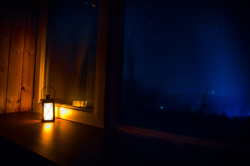 Night scene of stars seen through the window from dark room. Night sky inside dark room. Long...
