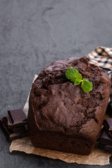 Homemade chocolate loaf cake on black stone background