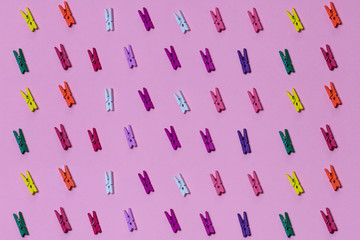 creative design, unusual art concepts.different colored plastic hangers on the pink table, top view