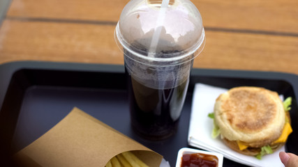 Soft drink with burger and french fries on tray, unhealthy dinner, junk food