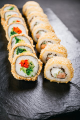 sushi, japanese food, deluxe restaurant menu, delicious traditional seafood. philadelphia and vegetarian tempura sushi rolls, served on black plate