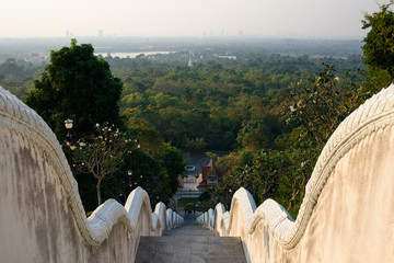 View on forest and Wat Yansangwararam temples and Pattaya city on the horizon from staircase of Phra Maha Mondop Phutthabat temple on the hill.