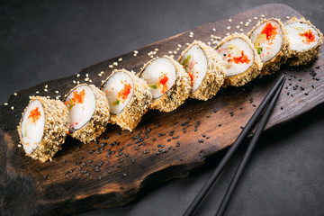 Tempura maki. Japanese sushi tempura roll on wooden platter. Japanese traditional fusion food...