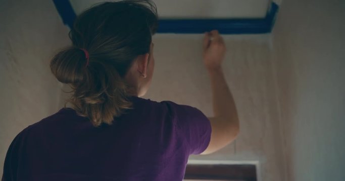 Young woman painting a small room