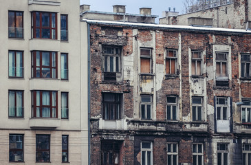 Modern residential building next to ruined tenement in Warsaw city, Poland