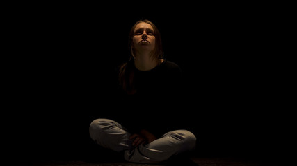 Depressed woman praying for end of suffering, victim of domestic violence