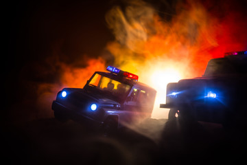 Police car chasing a car at night with fog background. 911 Emergency response police car speeding to scene of crime. Selective focus