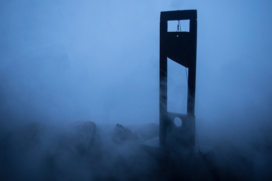 Horror view of Guillotine. Close-up of a guillotine on a dark foggy background.