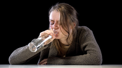 Alcoholic woman drinking vodka, domestic violence victim trying to forget pain