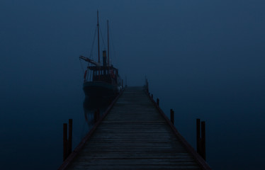 Boat at the pier in time of fog by night