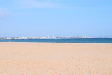 The big beach Meia Praia in Lagos, Algarve, Portugal with view to the city of Alvor