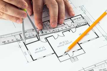 Male hands, Orange helmet, pencil, architectural construction drawings, tape measure. The architect designs the building. The concept of architecture, construction, engineering, design. Copy space.