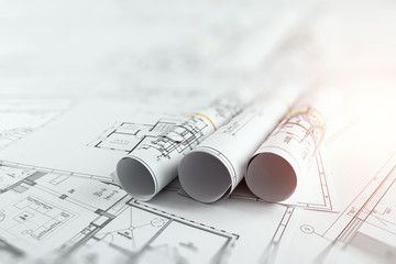 Architectural construction drawings twisted into a roll, construction projects on paper. The...