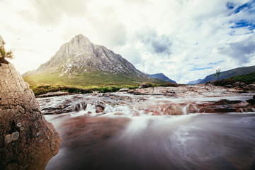 Beautiful river mountain landscape scenery in Glen Coe, Scottish Highlands, Scotland. Sunshine.