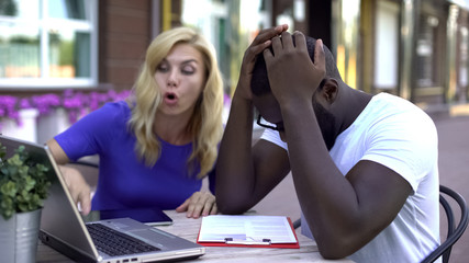 Nervous business people arguing, looking at laptop and paperboard, troubles