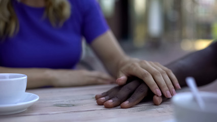 Fototapeta na wymiar Caucasian girlfriend touching african american male hand, support and love