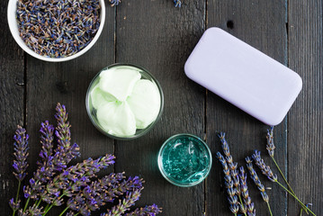 hygiene and skin care product samples with lavender flowers on black wooden