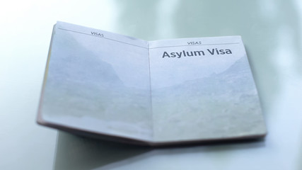 Asylum visa, opened passport lying on table in customs office, travelling