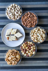 Oriental dessert halva with pistachio, almond, cashew nuts, peanut, walnut  on a  plate. Image. Healthy food. Nuts mix assortment. sweets, Turkish Delight. Isolated  background.. Eastern delicacy