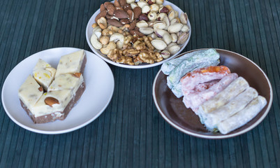 Traditional Turkish Delight. Oriental dessert halva on a  plate. Isolated on background. Eastern delicacy sweets. food. Nuts mix assortment pistachios, almond, cashew nuts, peanut, walnut on top view.