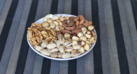 Healthy food. Nuts mix assortment on stone texture top view. Collection of different legumes for background image close up nuts, pistachios, almond, cashew nuts, peanut, walnut. image