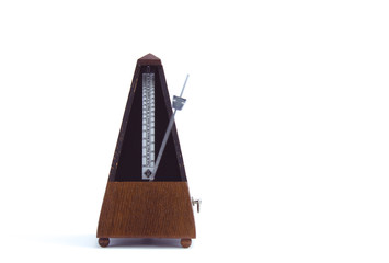 old classic metronome in motion in brown wood