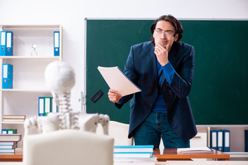 Male teacher and skeleton student in the classroom 