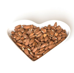 Nuts arranged in heart  on background. Healthy Food image close up almond on the cup plate. Love Texture on white grey table top view mock up