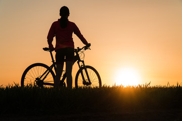 Fototapeta na wymiar woman at sunset from sunset Bike bike. woman practicing sports.