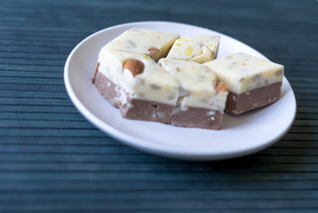 Oriental dessert halva with pistachio, almond, cashew nuts, peanut, walnut  on a  plate. Image. Healthy food. closeup of sweets  at the Machane Yehuda Market, Turkish Delight. Isolated on background